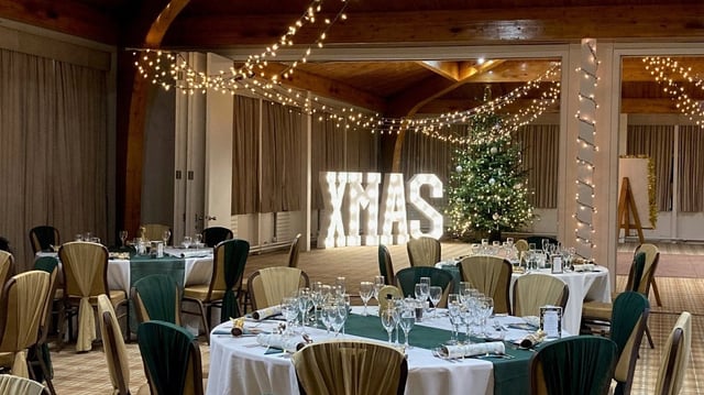 Christmas decorations in The Safari Lodge, showing tables, lit up word saying XMAS and Christmas tree