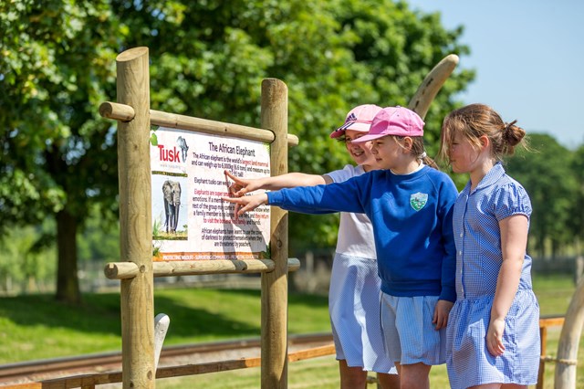 School kids point to sign in Tusk Garden