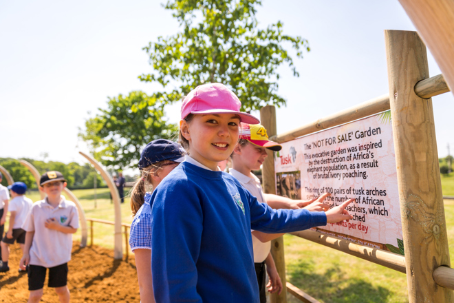 Students read the informational posters at Woburn Safari Park's TUSK charity ornamental garden