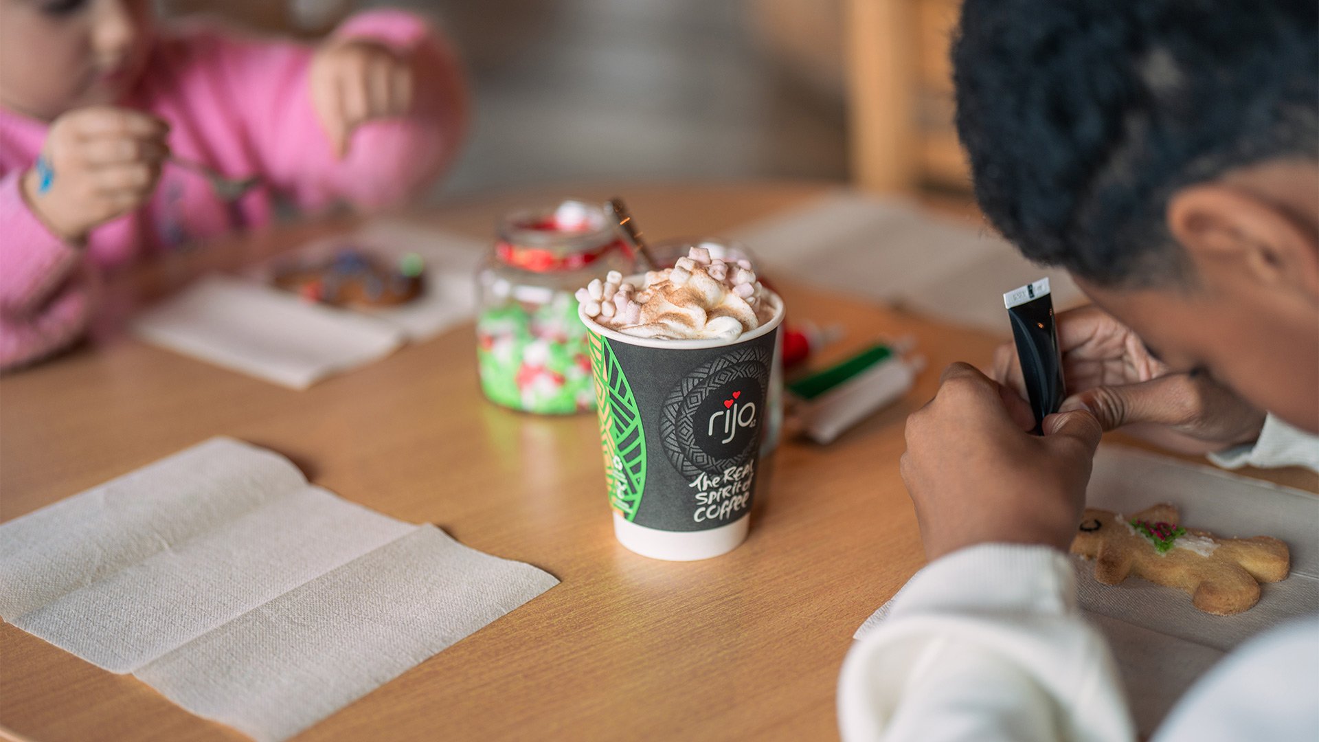Two kids decorating festive biscuits