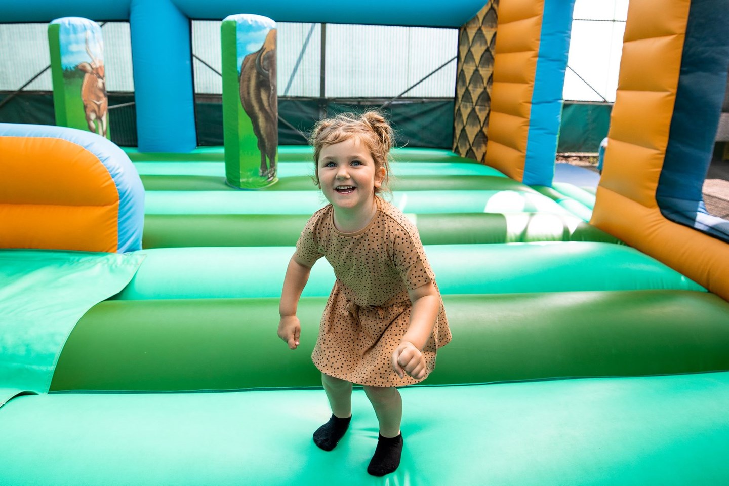 Little girl smiles as she bounces on bouncy castle 