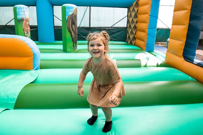 Little girl smiles as she bounces on bouncy castle 