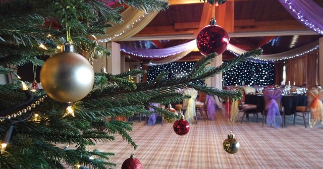 A Christmas tree standing in a banquet hall decorated for Christmas
