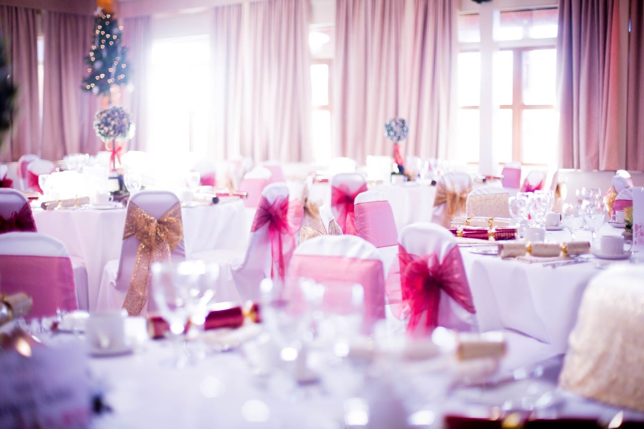 Christmas themed tables decorated in the Safari Lodge with pink and gold ribbons and Christmas trees
