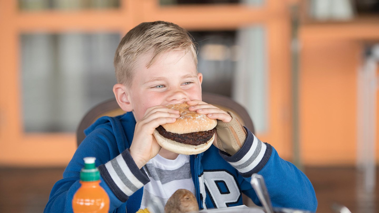 A child eating a burger at the Safari Lodge at Woburn Safari Park